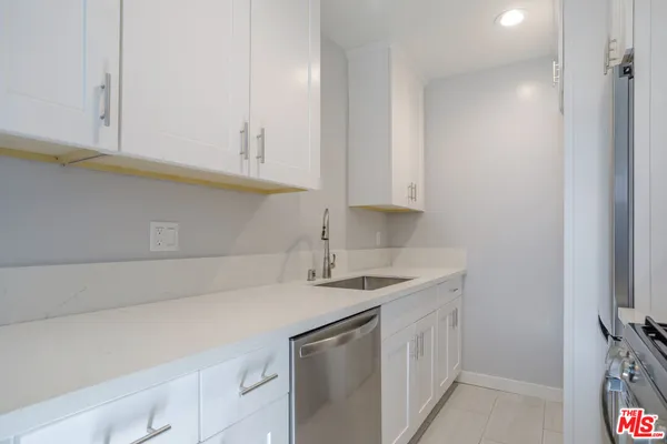 a view of kitchen with sink and refrigerator