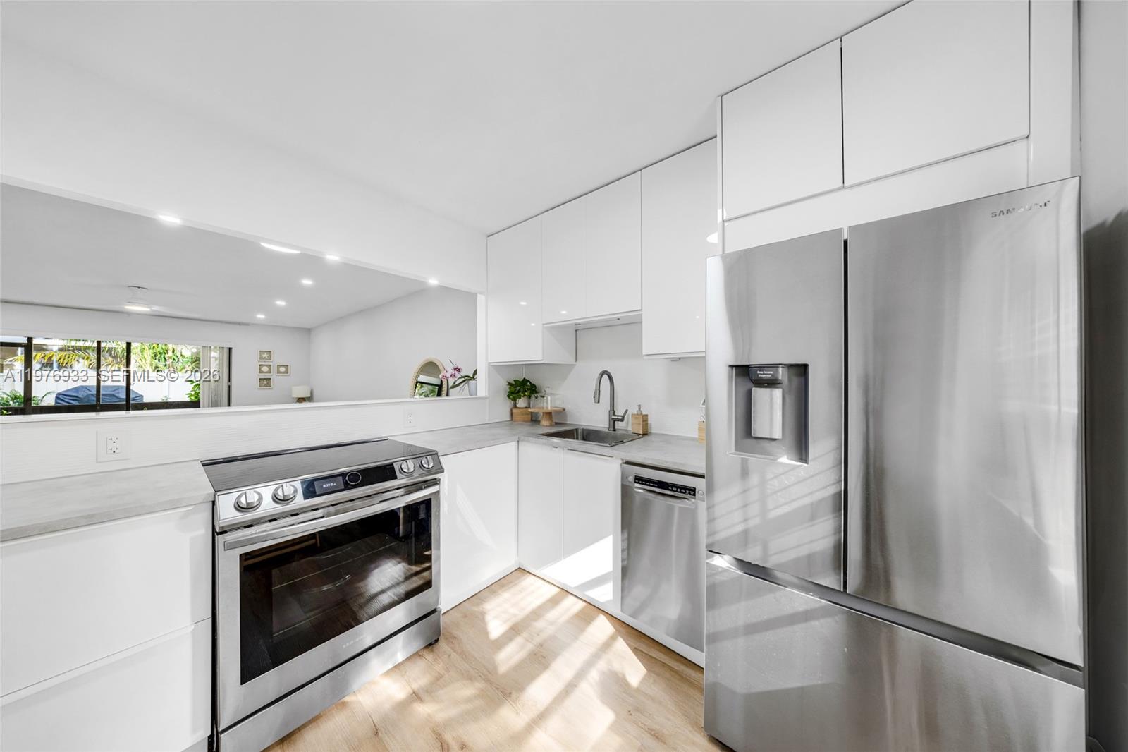 a kitchen with stainless steel appliances granite countertop a refrigerator a stove and a sink