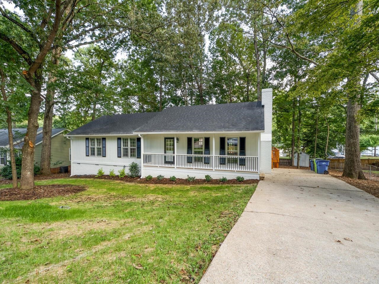 4504 Wenchelsea Place Raleigh, NC 27612 - Photo 2 of 27 a front view of a house with a garden and trees