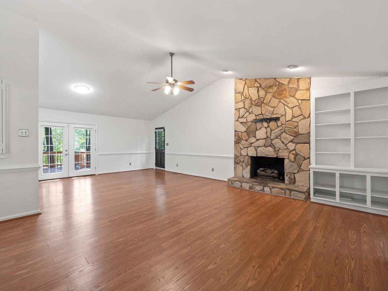 4504 Wenchelsea Place Raleigh, NC 27612 - Photo 6 of 27 an empty room with wooden floor fireplace and windows