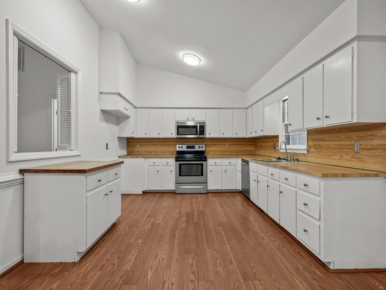 4504 Wenchelsea Place Raleigh, NC 27612 - Photo 9 of 27 a kitchen with granite countertop white cabinets and white appliances