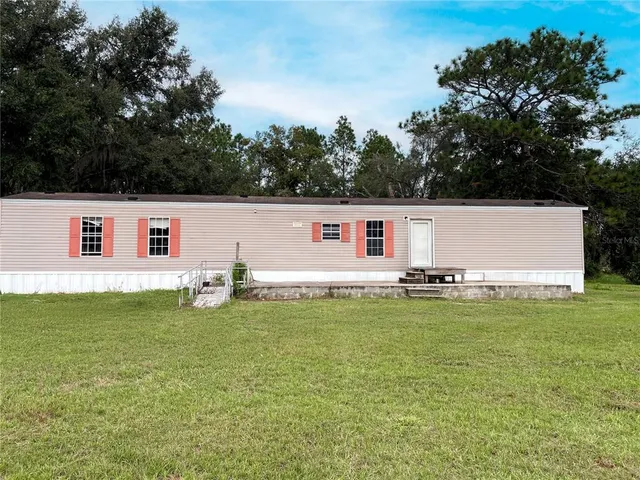 a white house that has a tree in front of it