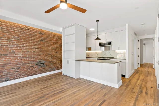 a kitchen with granite countertop a stove cabinets and wooden floor