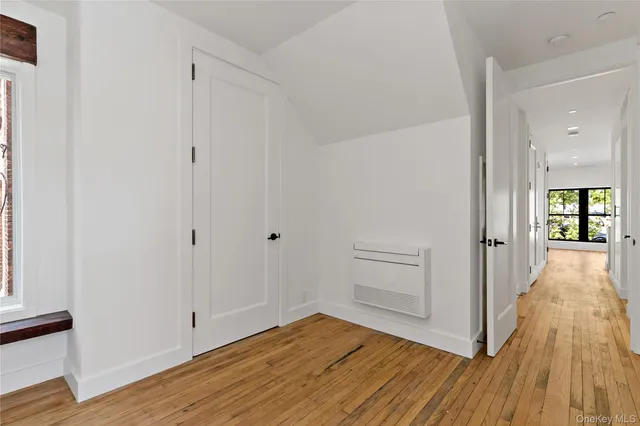 a view of a hallway with wooden floor and closet