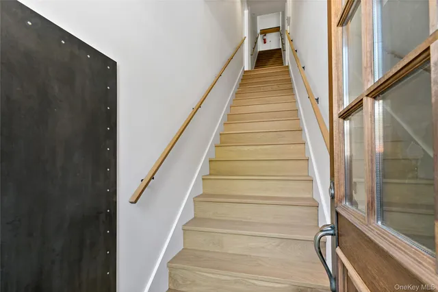 a view of staircase with wooden floor and white walls