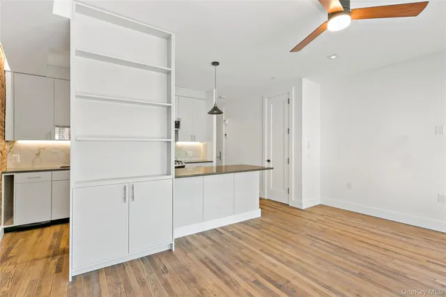 a view of a kitchen with white cabinets and wooden floor