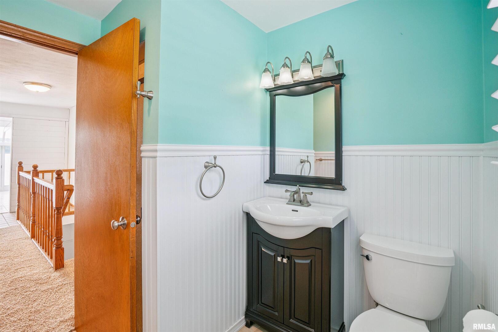 22799 Great River Road Le Claire, IA 52753 - Photo 16 of 48 a bathroom with a sink mirror toilet and vanity