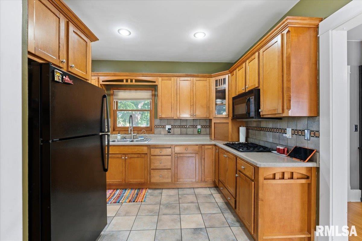 101 South Stewart Street Geneseo, IL 61254 - Photo 17 of 41 a kitchen with stainless steel appliances granite countertop a refrigerator and a stove top oven