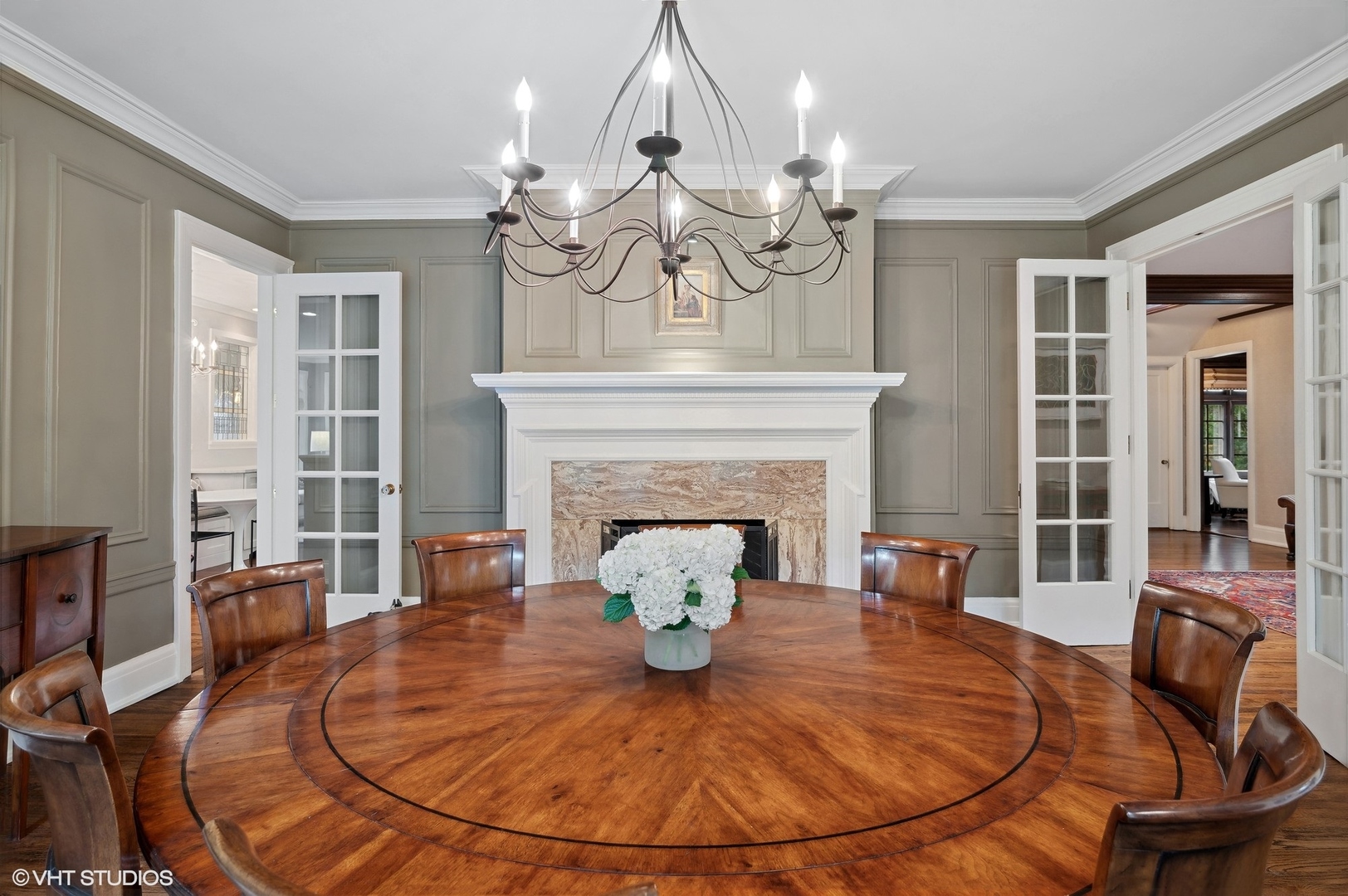 888 Tower Road Winnetka, IL 60093 - Photo 26 of 80 a view of a livingroom with furniture a fireplace wooden floor and chandelier