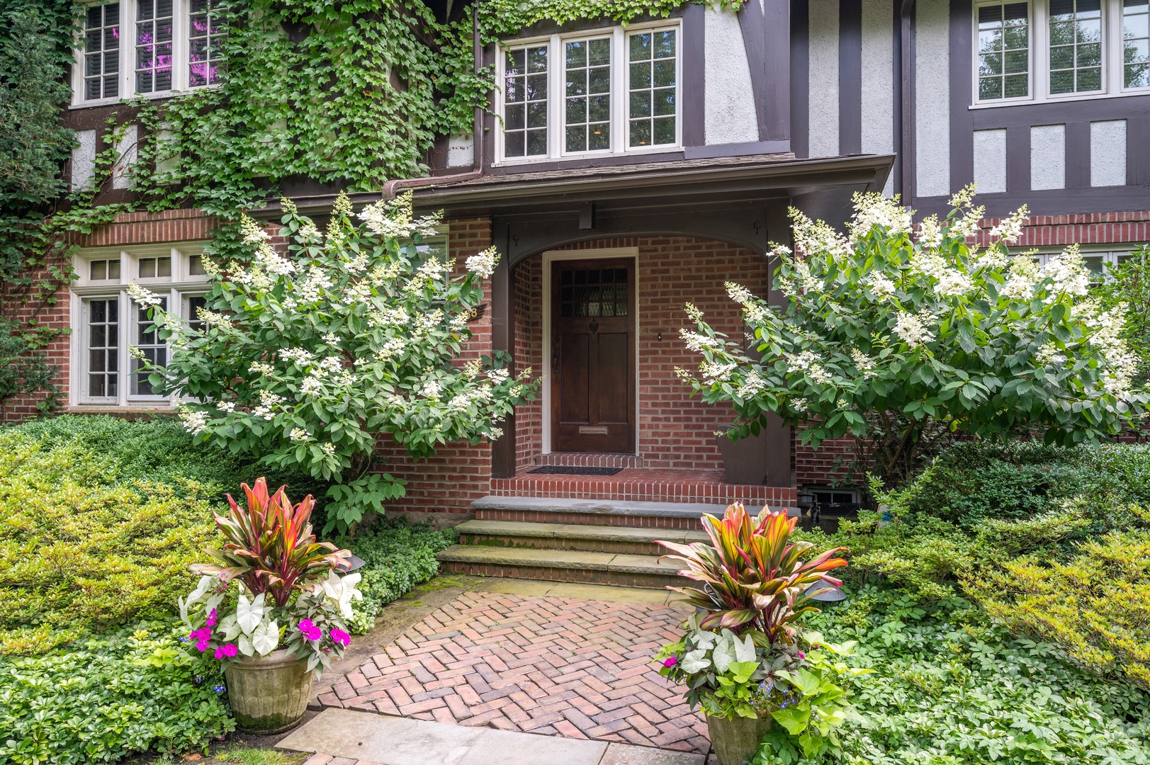 888 Tower Road Winnetka, IL 60093 - Photo 3 of 80 a front view of a house with a yard and flowers