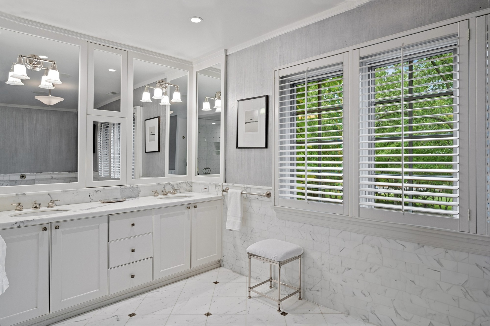 888 Tower Road Winnetka, IL 60093 - Photo 39 of 80 a bathroom with a double vanity sink a large mirror a bathtub and next to a window