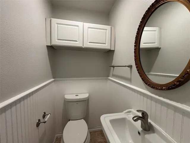 a bathroom with a toilet sink and mirror