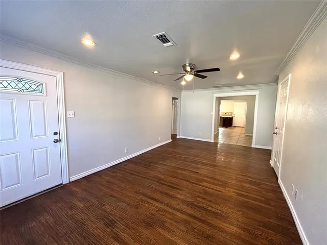 a view of an empty room with wooden floor