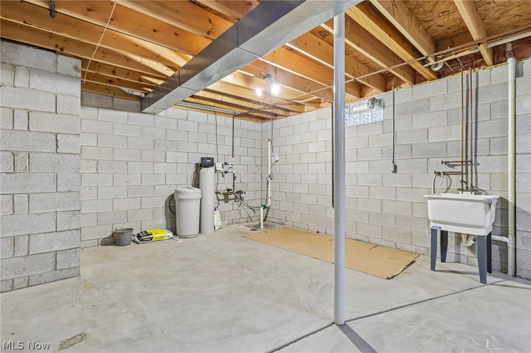 7007 Clingan Road, Unit 85 Youngstown, OH 44514 - Photo 35 of 46 Unfinished basement featuring exposed wood joists, concrete block walls, and a utility sink