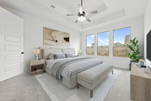 a spacious bedroom with a large bed and a chandelier