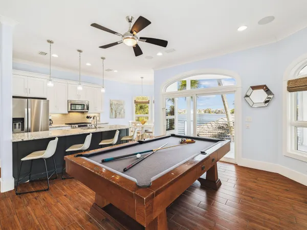a living room with stainless steel appliances kitchen island granite countertop furniture a rug and a wooden floor