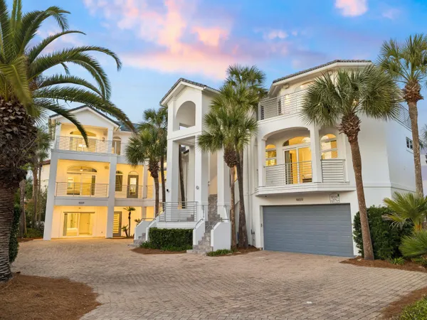 a view of a white building with a palm tree