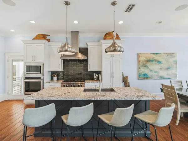 a kitchen with a dining table chairs and living room view