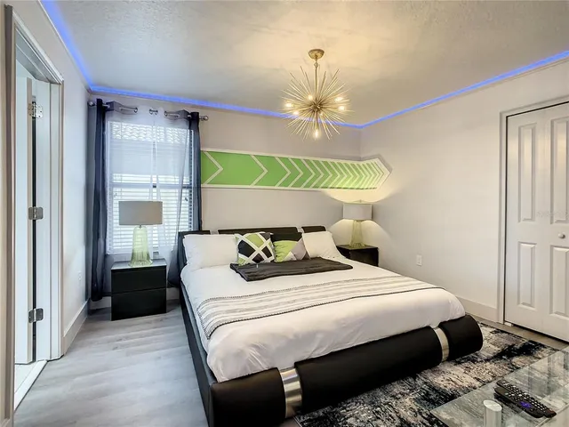 a bedroom with a bed a chandelier and a window