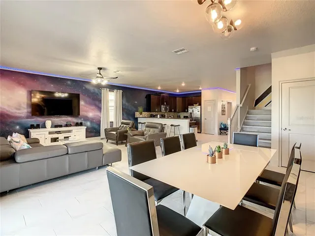 a kitchen with a dining table chairs stainless steel appliances and cabinets