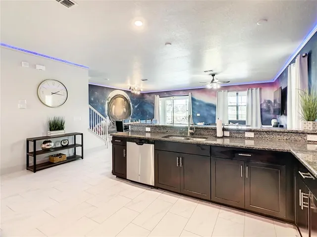 a kitchen with granite countertop a sink cabinets and wooden floor