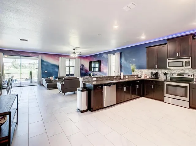 a large kitchen with stainless steel appliances kitchen island granite countertop a large counter top and stove