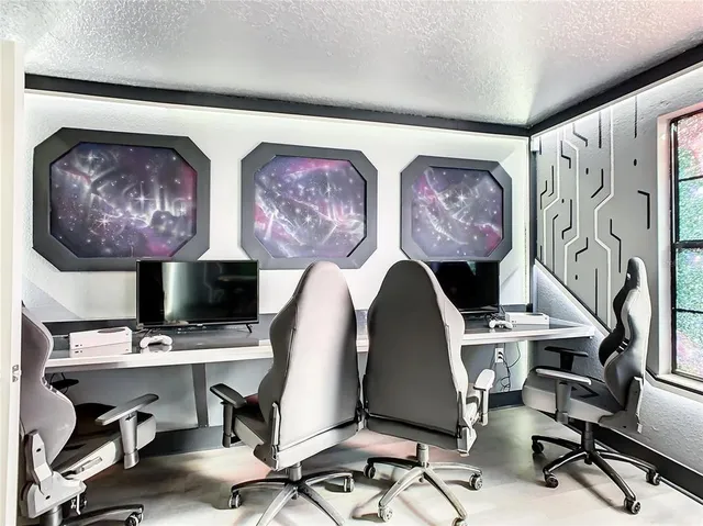 a view of workspace with painting on the wall and a desk