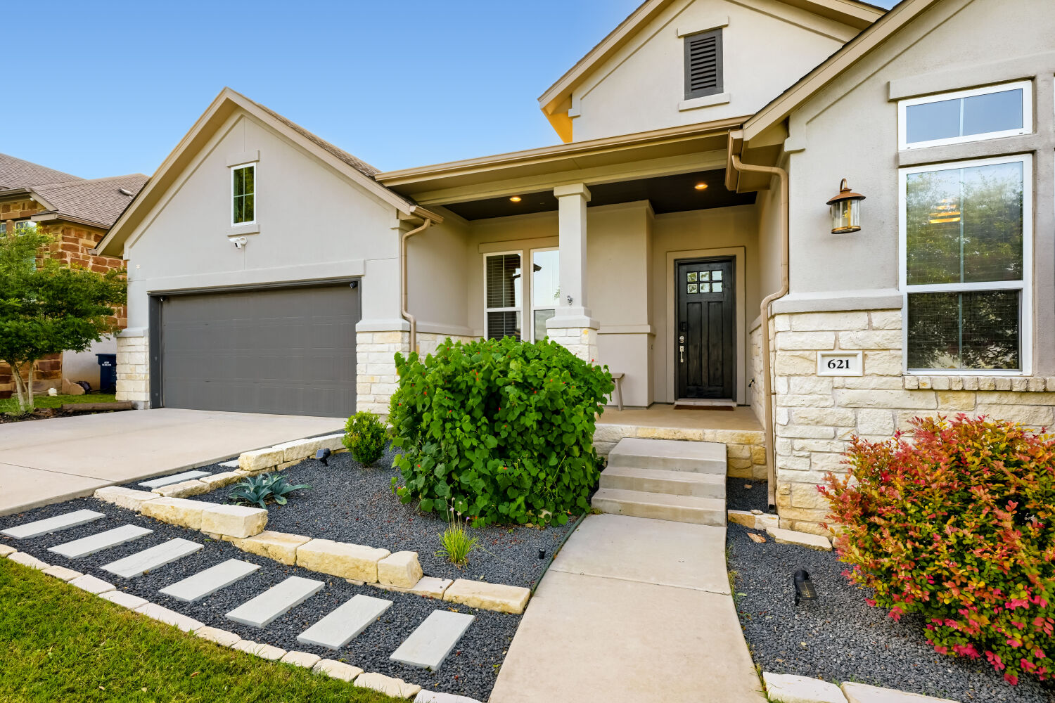 621 Rancho Sienna Loop Georgetown, TX 78628 - Photo 3 of 28 A well-maintained facade showcasing a welcoming entryway with a dark door and neat landscaping.