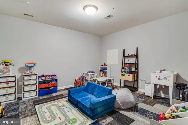 a living room with furniture a rug and a bookshelf