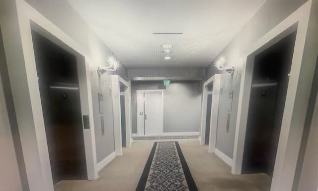 a view of hallway with closet and wooden floor