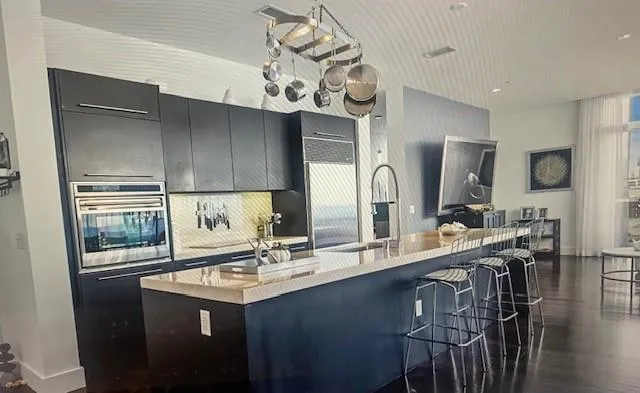 a kitchen with a sink a counter space and stainless steel appliances