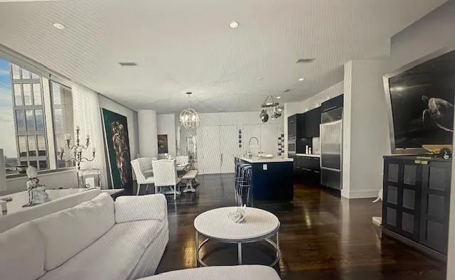 a living room with furniture a large window and kitchen view