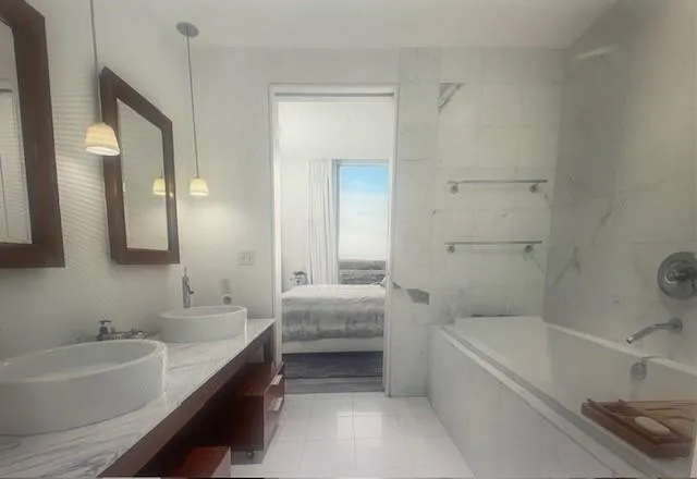 a bathroom with a tub double vanity sink and mirror