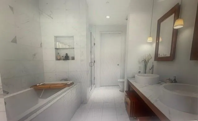 a bathroom with a tub sink and mirror