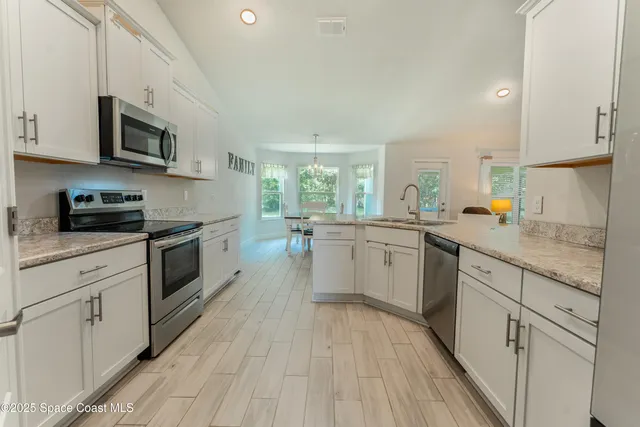 a kitchen with stainless steel appliances a white stove top oven sink and cabinets