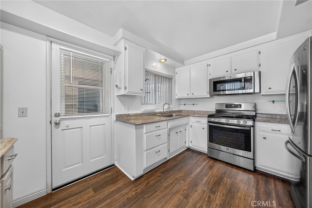29078 Bradley Road Menifee, CA 92586 - Photo 15 of 42 a kitchen with granite countertop white cabinets and appliances