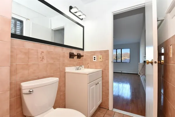 a bathroom with a toilet sink and mirror