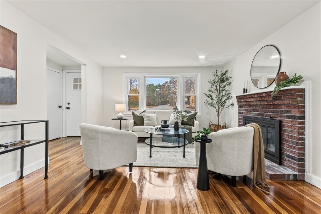 a living room with fireplace furniture and a wooden floor