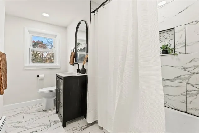 a bathroom with a sink a toilet and shower