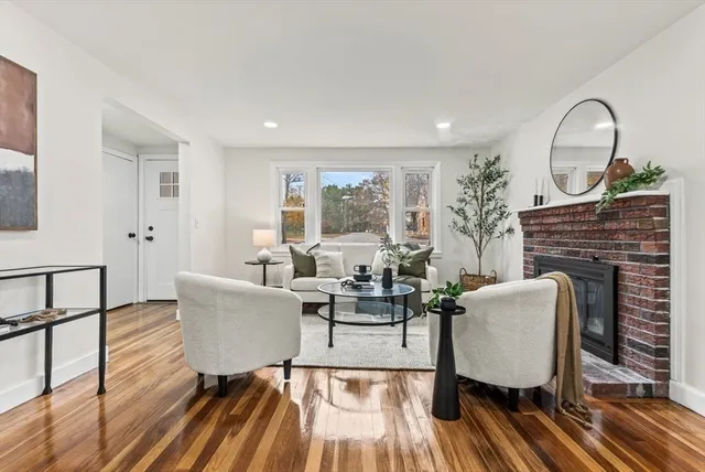 a living room with fireplace furniture and a wooden floor