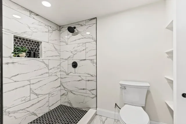 a bathroom with a toilet and a shower