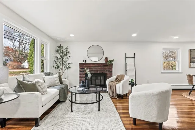 a living room with furniture a large window and a fireplace