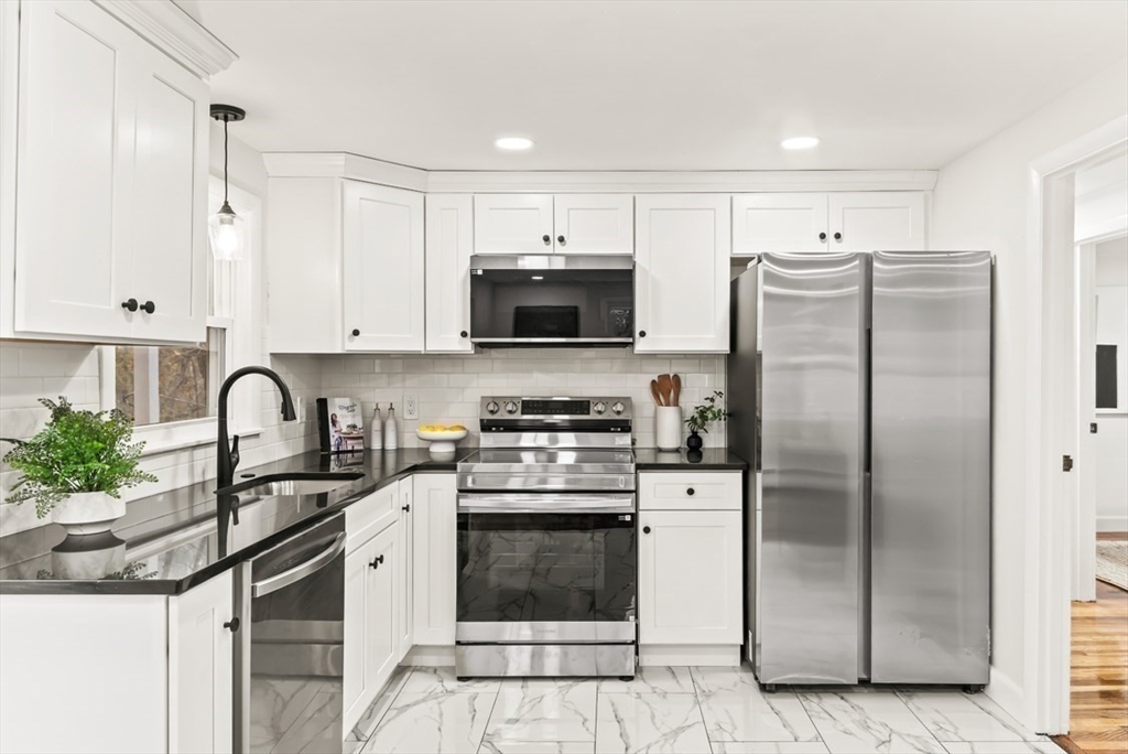 1156 Washington Street Walpole, MA 02081 - Photo 8 of 26 a kitchen with stainless steel appliances granite countertop a stove a refrigerator and a sink