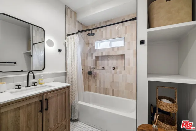a bathroom with a tub sink shower and a mirror
