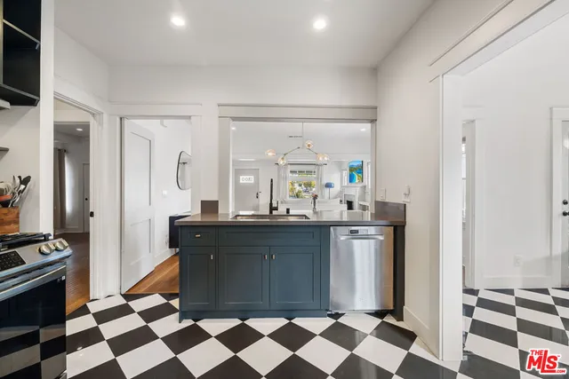 a room with a black white checkered floor and a sink