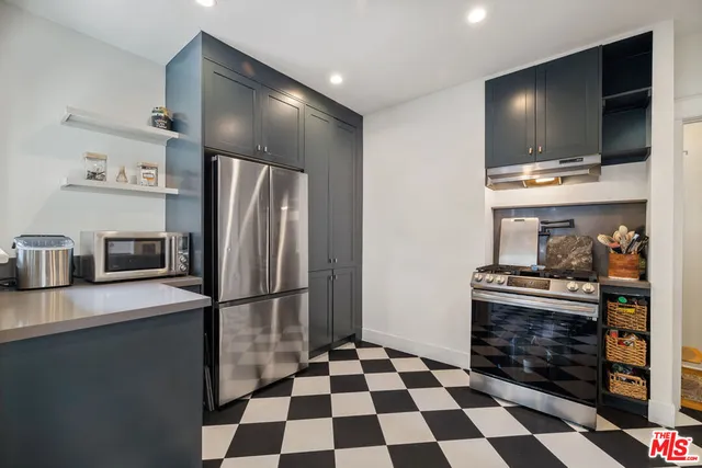 a kitchen with stainless steel appliances granite countertop a refrigerator and a stove top oven