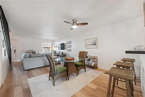 a kitchen with stainless steel appliances a table and chairs in it