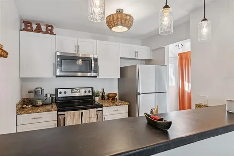 a kitchen with granite countertop a sink a counter and cabinets