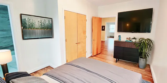 a bedroom with a bed and a flat screen tv