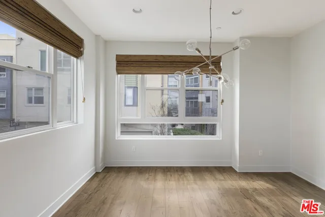 a view of an empty room with a window and chandelier